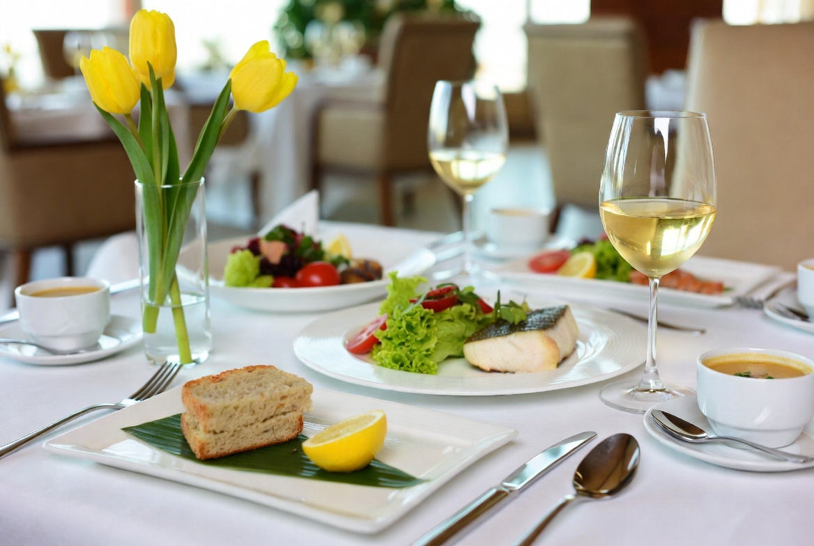 Close-up of beautifully plated gourmet dish with yellow tulip garnish at Tulip Flowers catering event in Oman